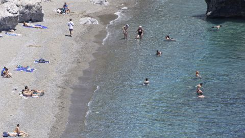 Tourists enjoy the summer sun at the sandy beach at Preveli, a popular tourist destination in the Mediterranean sea with the freshwater river, the palm tree forest and the entrance of the rocky gorge. The beach has crystal clear waters and is connected by a ferry boat to nearby town and beach. The famous palm tree forest has the native Phoenix theophrasti, the Cretan date palm honoring the ancient Greek philosopher and naturalist Thoephrastus. Preveli Beach, Crete, Greece on May 11, 2025 (Photo by Nicolas Economou/NurPhoto via Getty Images)