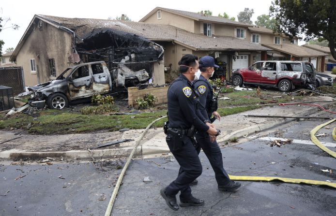 Agentes de policía registran el lugar donde una avioneta se estrelló en una calle residencial de San Diego, California, el 22 de mayo de 2025.