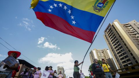 A er of the ruling United Socialist Party of Venezuela (PSUV) waves a national flag during a closing campaign rally ahead of the parliamentary and regional election in Caracas on May 22, 2025. Venezuela will hold parliamentary and regional elections on May 25. (Photo by Pedro MATTEY / AFP) (Photo by PEDRO MATTEY/AFP via Getty Images)          