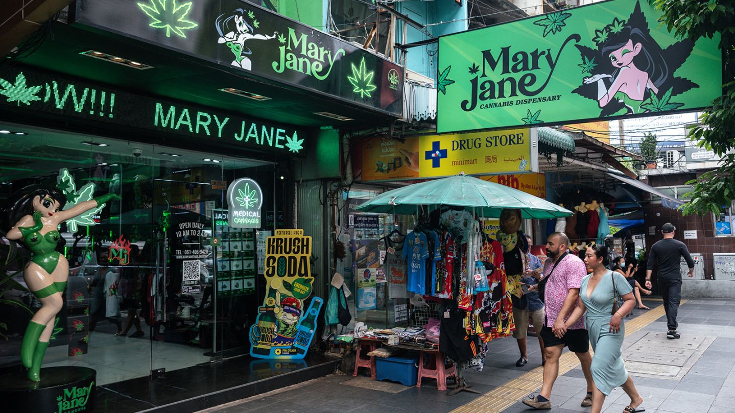 People walk past the Mary Jane cannabis dispensary in Bangkok on May 23, 2025.