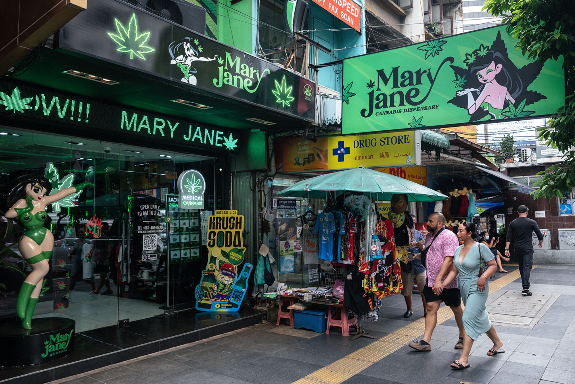 People walk past the Mary Jane cannabis dispensary in Bangkok on May 23, 2025.