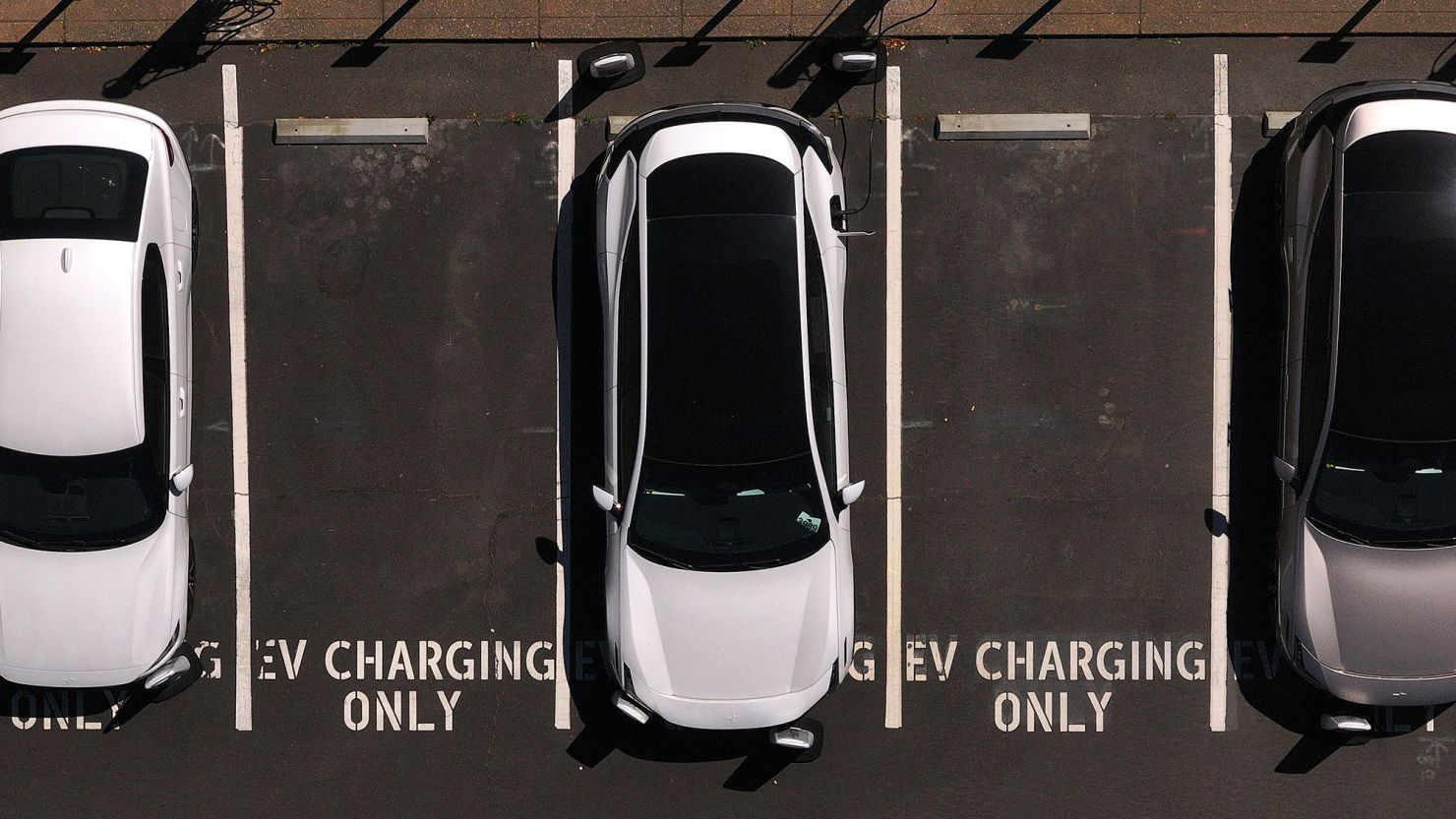 In an aerial view, electric cars sit parked at a charging station on May 19 in Corte Madera, California.