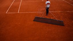 A staff sweeps a clay court during the French Open tennis tournament at the Roland-Garros Complex in Paris on May 24, 2025. (Photo by Dimitar DILKOFF / AFP) (Photo by DIMITAR DILKOFF/AFP via Getty Images)          