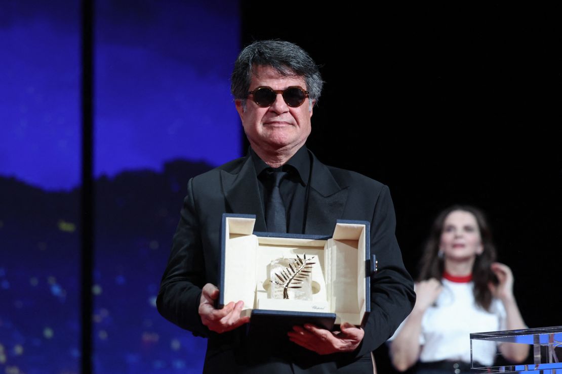 Panahi poses on stage after winning the Palme d'Or on May 24, 2025.