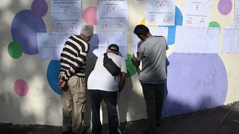 People check voting lists outside a polling station during the regional elections in Caracas on May 25, 2025. Venezuelans began electing their deputies and governors on Sunday, in an election that is expected to be largely won by the government, with most of the opposition boycotting it, ten months after the re-election of President Nicolas Maduro, whose victory they are contesting. (Photo by Federico PARRA / AFP) (Photo by FEDERICO PARRA/AFP via Getty Images)          