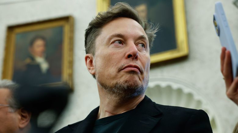 Elon Musk listens as reporters ask U.S. President Donald Trump and South Africa President Cyril Ramaphosa questions during a press availability in the Oval Office at the White House on May 21, 2025 in Washington, DC.