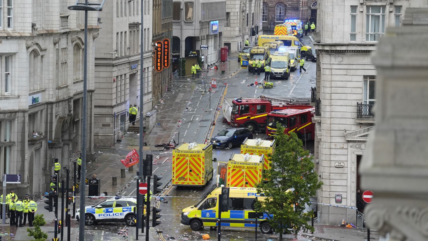 Emergency personnel work at the scene where a driver plowed a car into a parade in Liverpool, England, on Monday.