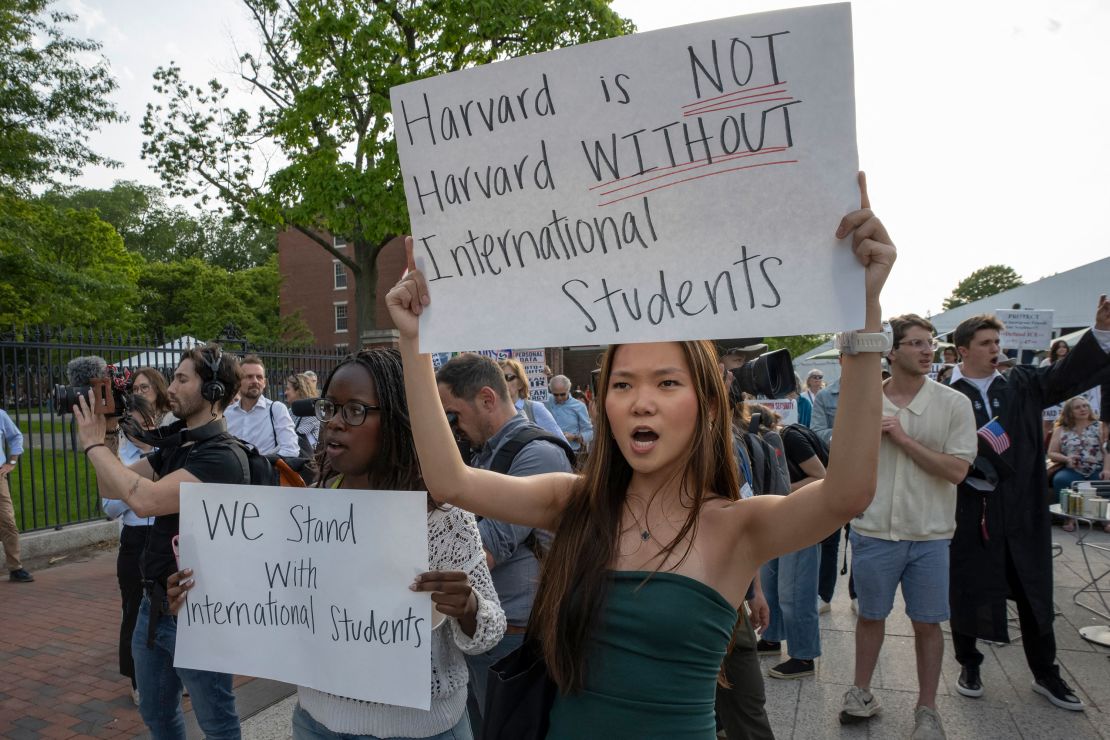 People hold up signs during a rally in support of Harvard University international students in Boston on Tuesday.