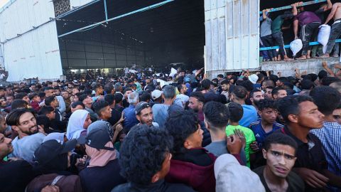 Palestinos desplazados transportan bolsas de ayuda alimentaria mientras irrumpen en un almacén del Programa Mundial de Alimentos en Deir el-Balah, en Gaza, el 28 de mayo de 2025.