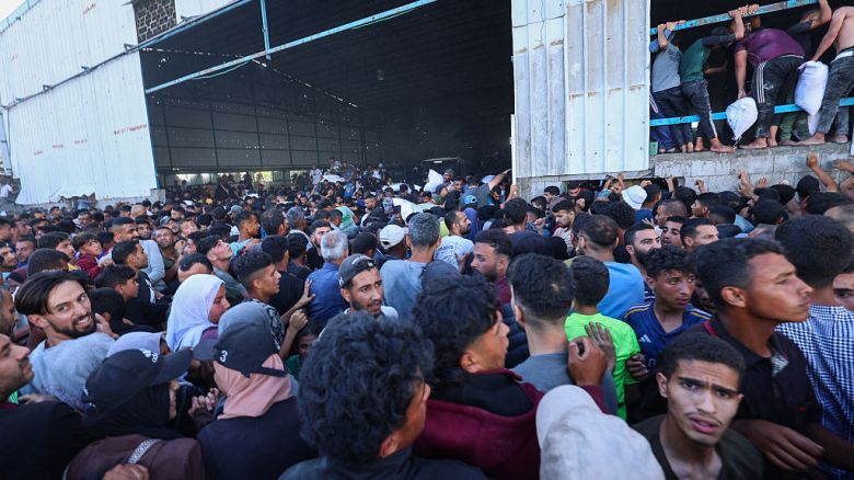Palestinos desplazados transportan bolsas de ayuda alimentaria mientras irrumpen en un almacén del Programa Mundial de Alimentos en Deir el-Balah, en Gaza, el 28 de mayo de 2025.