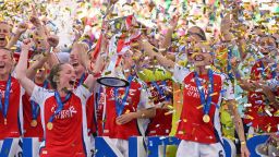 Kim Little and Leah Williamson lift the Women's Champions League trophy after their win.