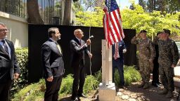 El ministro de Asuntos Exteriores sirio, Assaad al-Shibani (2.º por la izq.), observa al enviado especial de EE.UU. para Siria, el embajador en Turquía, Thomas Barrack, izar la bandera estadounidense en la residencia del embajador estadounidense en Damasco durante una ceremonia oficial celebrada el 29 de mayo de 2025.