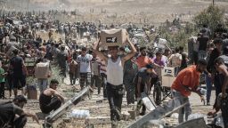 Palestinians carry boxes of humanitarian aid collected from a distribution center in the Netzarim Corridor, central Gaza Strip, on Thursday.