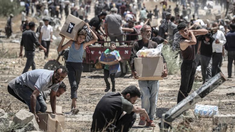 Palestinos trasladan cajas de ayuda humanitaria recogidas en un centro de distribución en el Corredor Netzarim, en el centro de la Franja de Gaza, el 29 de mayo.