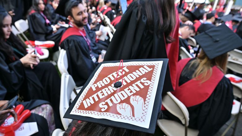  A Harvard University graduate with a message in support of international students on her mortarboard sits with fellow students at the start of commencement exercises at Harvard University in Harvard Yard May 29, 2025.