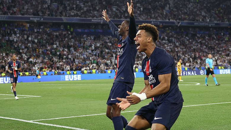 Paris Saint-Germain's French midfielder #14 Desire Doue (R) celebrates with Paris Saint-Germain's French forward #10 Ousmane Dembele (C) after scoring PSG's fourth goal during the UEFA Champions League final football match between Paris Saint-Germain (PSG) and Inter Milan in Munich, southern , on May 31, 2025. (Photo by FRANCK FIFE / AFP) (Photo by FRANCK FIFE/AFP via Getty Images)