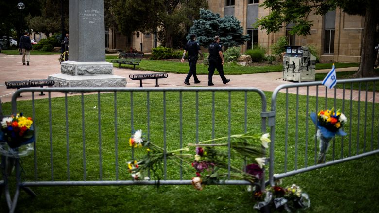 BOULDER, COLORADO - JUNE 2: Police officers walk past a barricade adorned with flowers outside the Boulder County Courthouse on June 2, 2025 in Boulder, Colorado. A suspect is in custody after reportedly throwing incendiary devices at a group participating in an organized walk to show solidarity with hostages held by Hamas in Gaza. The suspect, an Egyptian citizen who had overstayed his visa, has been charged with a hate crime by the F.B.I.  (Photo by Chet Strange/Getty Images)