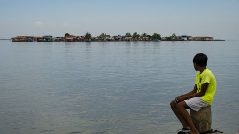 TOPSHOT - A child looks at Carti Tupile Island from Gardi Sugdub island, in the Guna Yala Archipelago, Panama on May 27, 2025. Streets once filled with children's laughter have fallen silent on Gardi Sugdub, a Panamanian island where almost all residents left a year ago due to the threat of the sea swallowing their homes. The evacuation of around 1,200 members of the Indigenous Guna community to a new life on the mainland was one of the first planned migrations in Latin America due to climate change. (Photo by MARTIN BERNETTI / AFP) (Photo by MARTIN BERNETTI/AFP via Getty Images)          