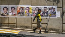 A man walks past posters of candidates during the presidential election in Seoul on June 3, 2025.