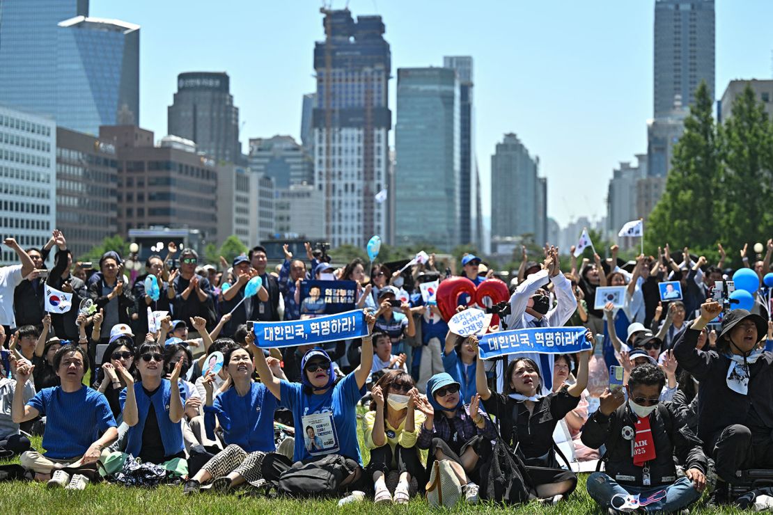 People cheer as they watch the inauguration ceremony of South Korea's President Lee Jae-myung outside the National Assembly in Seoul on June 4, 2025.