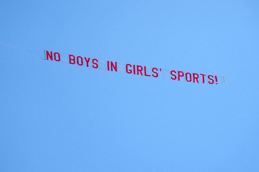 A plane tows a sign that reads "No boys in girls' sports!" during the CIF State Track and Field Championships on Friday.