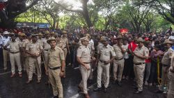 Police stand in front of crowds as fans gather outside the M. Chinnaswamy Stadium to celebrate Royal Challengers Bengaluru winning the Indian Premier League (IPL), in Bengaluru on June 4, 2025. Packed crowds in India celebrating their cricket team's victory ended in a deadly stampede on Wednesday with 11, mainly young, fans crushed to death, the local state's chief minister said. Joyous cricket fans had come out to celebrate and welcome home their heroes, Royal Challengers Bengaluru, after they beat Punjab Kings in the Indian Premier League cricket final the previous night. (Photo by AFP) (Photo by STRINGER/AFP via Getty Images)          