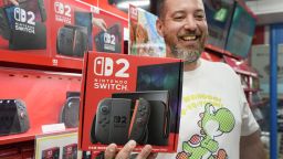 A French customer living in Tokyo smiles as he shows off a Nintendo Switch 2 bought at an electronics retailer in Tokyo on June 5, 2025. With shops planning midnight launch parties after a run on pre-orders, Nintendo releases the Switch 2 on June 5, hoping to score record early sales for the games console. (Photo by Kazuhiro NOGI / AFP) (Photo by KAZUHIRO NOGI/AFP via Getty Images)          