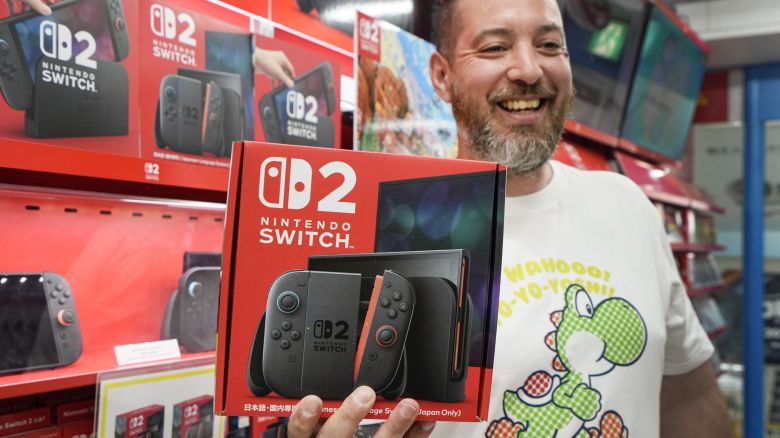 A French customer living in Tokyo smiles as he shows off a Nintendo Switch 2 bought at an electronics retailer in Tokyo on June 5, 2025. With shops planning midnight launch parties after a run on pre-orders, Nintendo releases the Switch 2 on June 5, hoping to score record early sales for the games console. (Photo by Kazuhiro NOGI / AFP) (Photo by KAZUHIRO NOGI/AFP via Getty Images)          