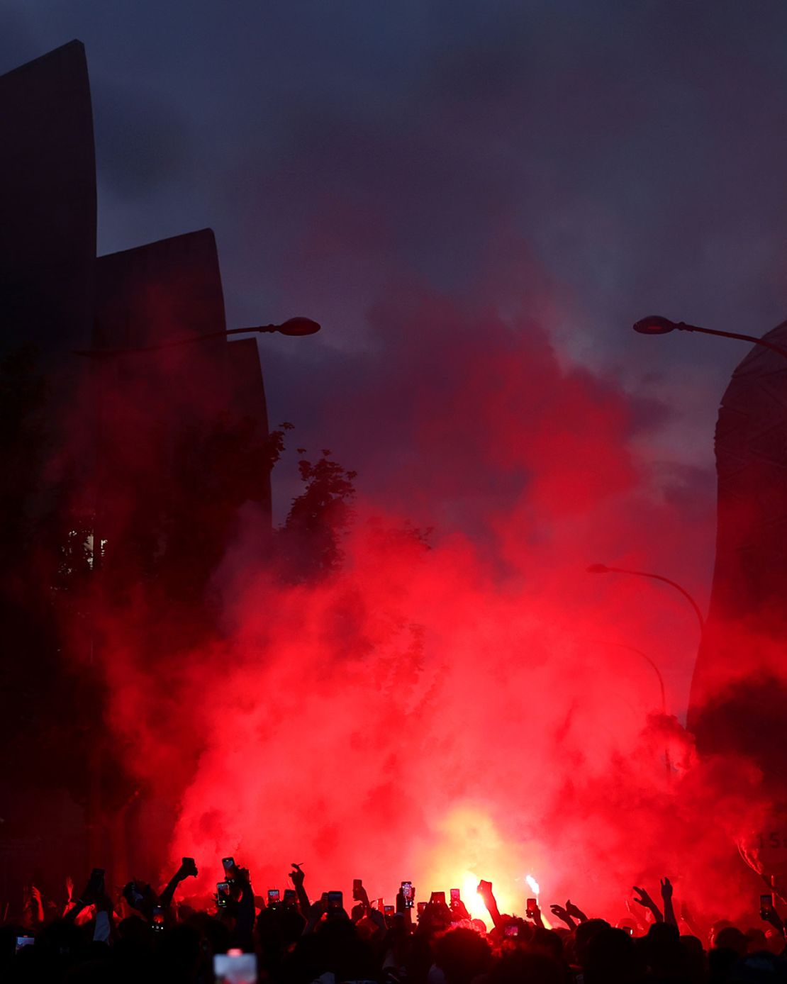 Fans of Paris Saint-Germain set off red smoke flares.