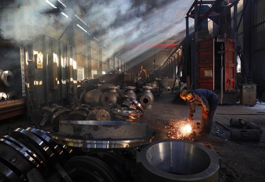 A worker polishes machinery at a workshop of a steel machinery factory in Hangzhou, in eastern China's Zhejiang province on June 6.