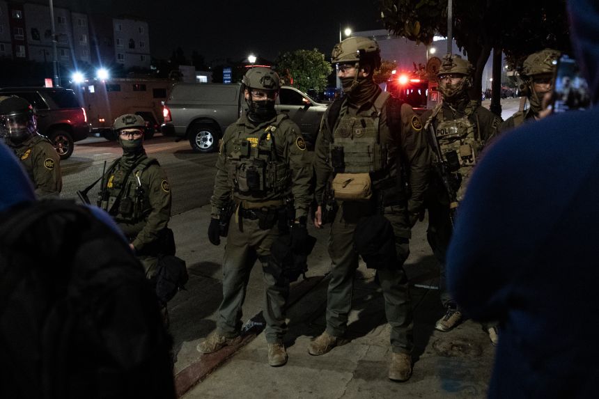 ICE officers form a barrier June 6 to block protesters after a raid in Los Angeles.