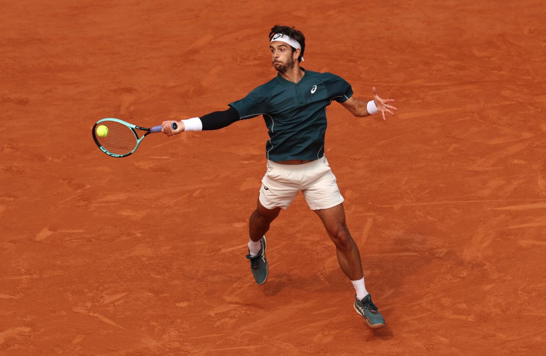 Musetti plays a forehand against Tiafoe.