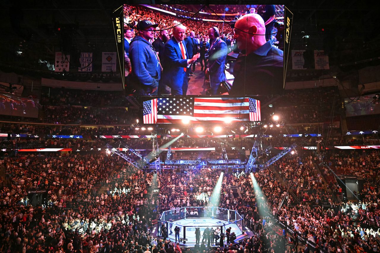 President Donald Trump is seen on a jumbotron above the octagon at UFC 316 in Newark, New Jersey, on Saturday.