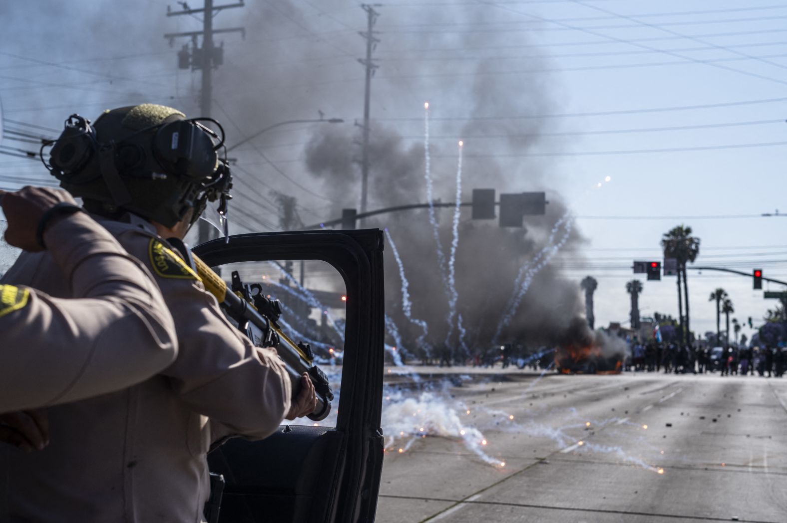 Law enforcement clash with demonstrators during a protest in the Compton neighborhood of Los Angeles on Saturday.