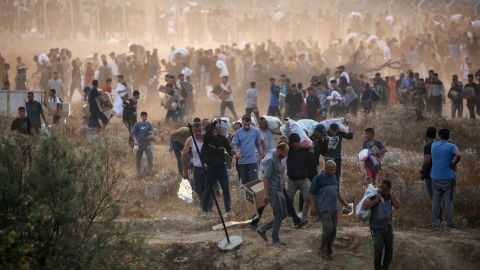 TOPSHOT - People carry relief supplies from the Gaza Humanitarian Foundation (GHF), a private US-backed aid group that has bypassed the longstanding UN-led system in the territory, as displaced Palestinians return from an aid distribution centre in the central Gaza Strip on June 8, 2025. The UN and major aid organisations have refused to cooperate with the GHF, citing concerns that it was designed to cater to Israeli military objectives. (Photo by Eyad BABA / AFP) (Photo by EYAD BABA/AFP via Getty Images)          