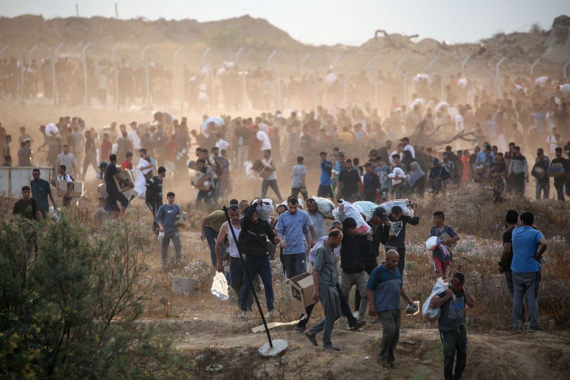 People carry relief supplies from the Gaza Humanitarian Foundation (GHF) in central Gaza on Sunday.