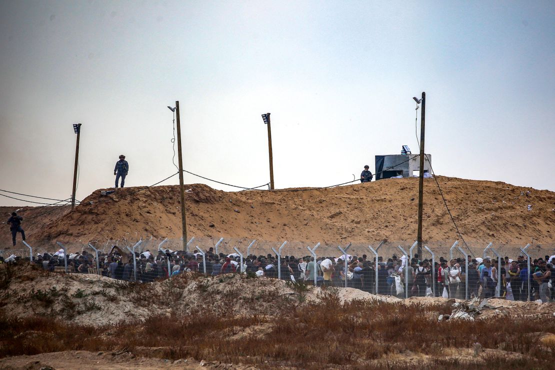 Members of a private US security company, contracted by the Gaza Humanitarian Foundation (GHF), direct displaced Palestinians as they gather to receive relief supplies at a distribution center in the central Gaza Strip on June 8, 2025.