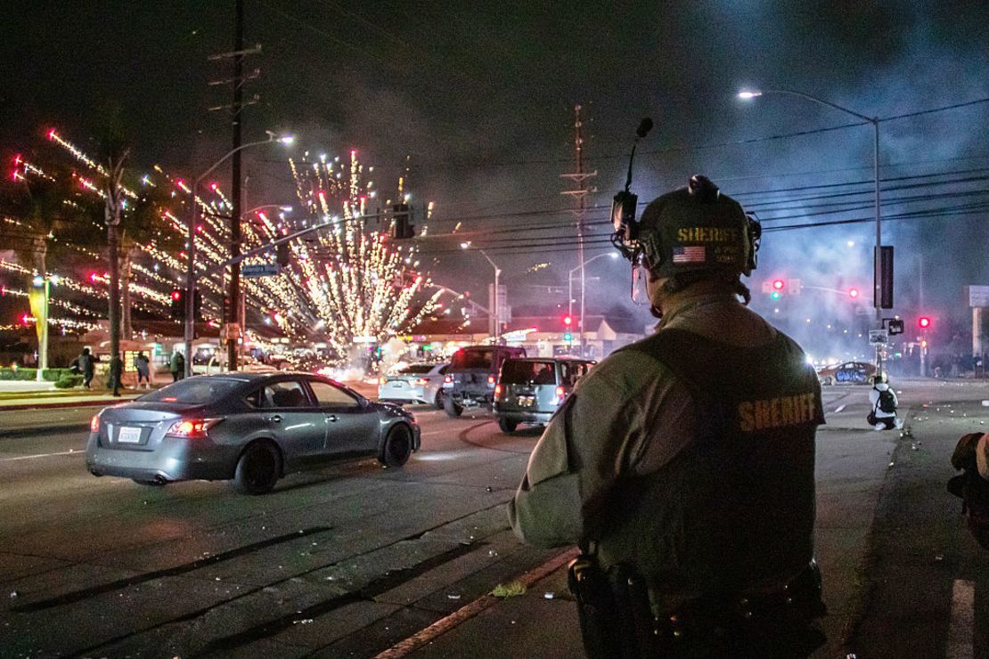 Fuegos artificiales lanzados por manifestantes explotan cerca de agentes del Departamento del Sheriff de Los Ángeles durante una protesta migratoria el 7 de junio de 2025 en Paramount, California. Los enfrentamientos entre la Patrulla Fronteriza de EE.UU. y los manifestantes comenzaron después de que ICE realizara una redada en un Home Depot.