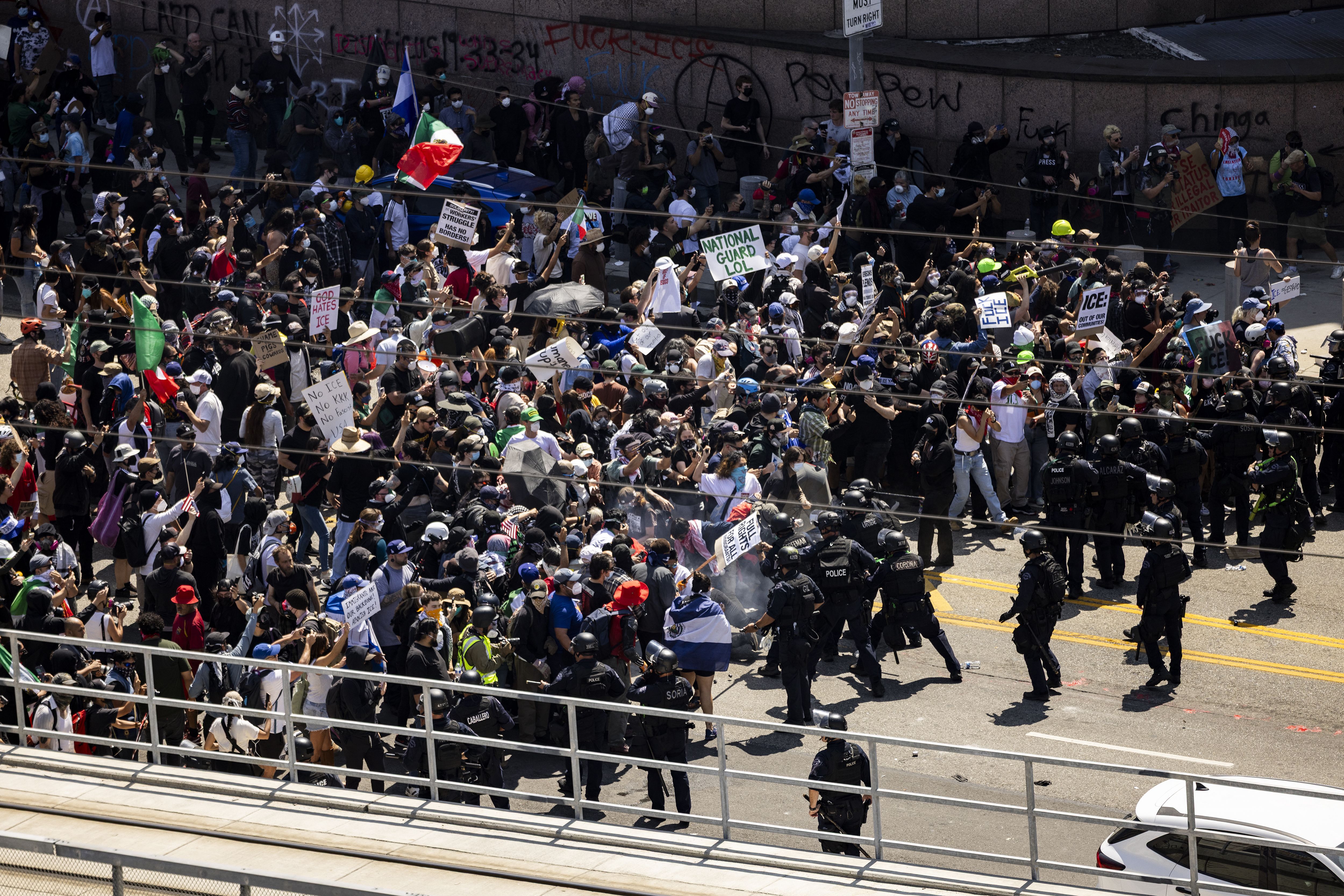 Law enforcement clash with demonstrators in front of the federal building during a protest in Los Angeles on Sunday.