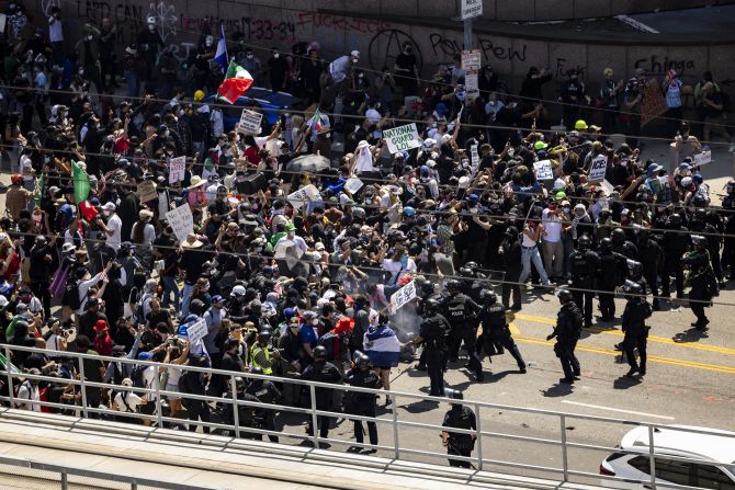 Law enforcement clash with demonstrators in front of the federal building during a protest in Los Angeles on Sunday.