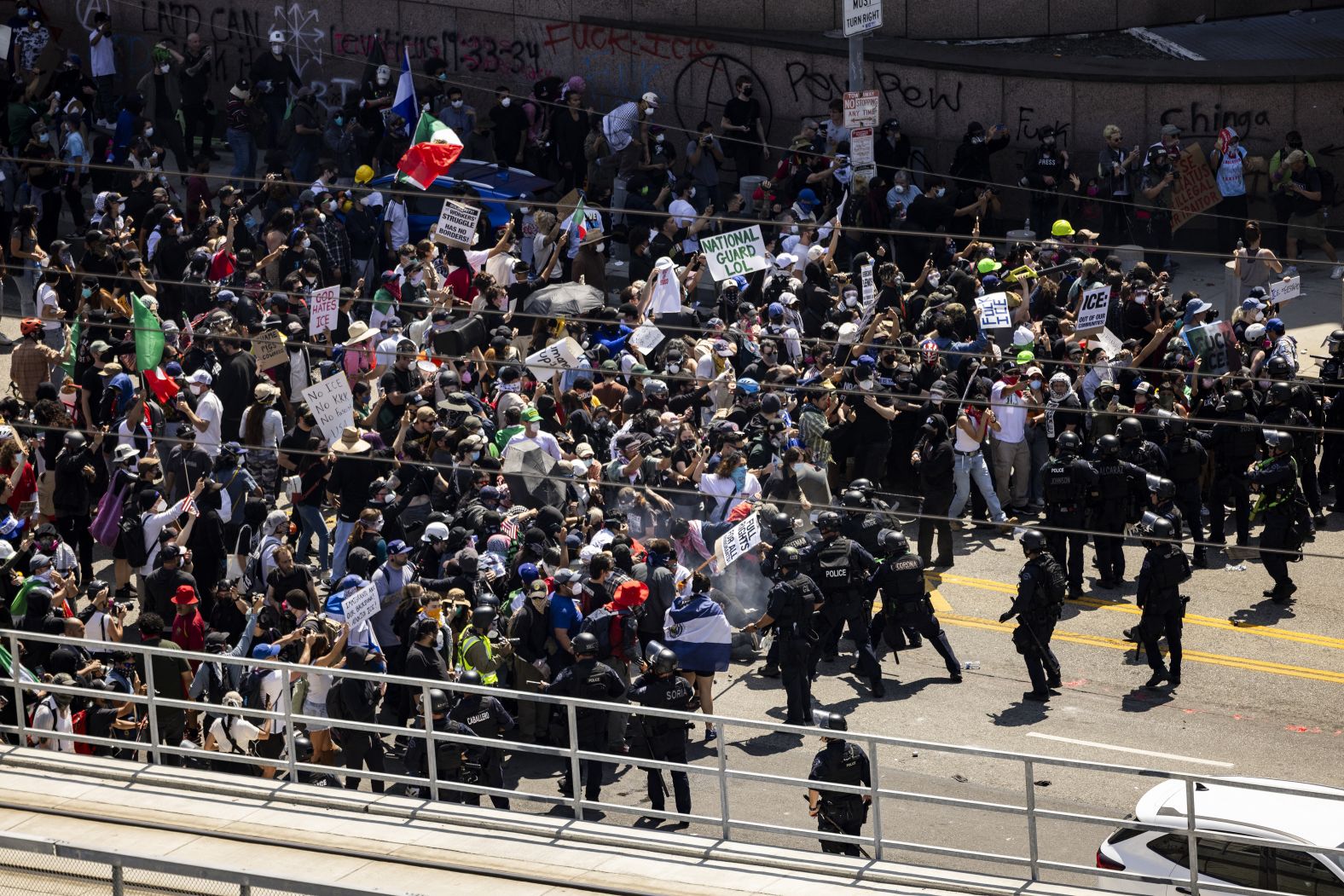 Law enforcement clash with demonstrators in front of the federal building during a protest in Los Angeles on Sunday.