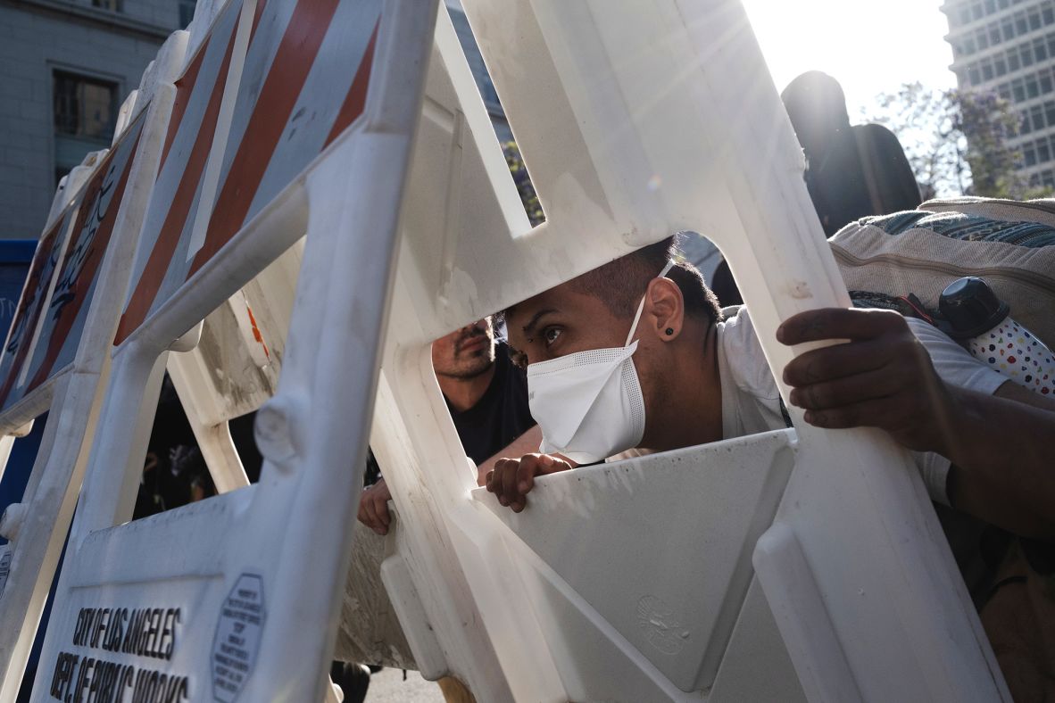 Protesters hide behind barricades as law enforcement officers shoot projectiles at them on Sunday.