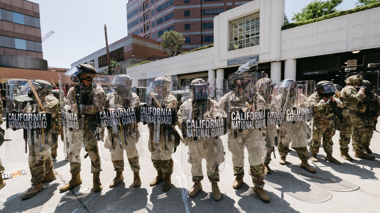 National Guard troops stand in front of a government building during a protest in Los Angeles, California, on June 8, 2025. Following a series of aggressive federal immigration operations in Los Angeles, tensions escalated when Immigration and Customs Enforcement (ICE) agents conducted a high-profile raid on a Home Depot location. The raid sparked widespread protests across the city, where demonstrators decried the targeting of immigrant communities and the separation of families. Clashes soon broke out between protesters and federal agents, prompting U.S. President Donald Trump to deploy 2,000 National Guard troops to the city, a move harshly criticized by California officials, including the governor, as "purposefully inflammatory." (Photo by David Pashaee / Middle East Images via AFP) (Photo by DAVID PASHAEE/Middle East Images/AFP via Getty Images)          