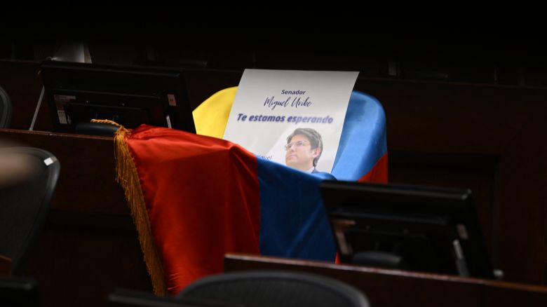 Una foto del senador y candidato presidencial colombiano Miguel Uribe con la frase "Te esperamos" sobre una bandera colombiana se ve sobre su escaño en el Congreso de Bogotá el 9 de junio de 2025.