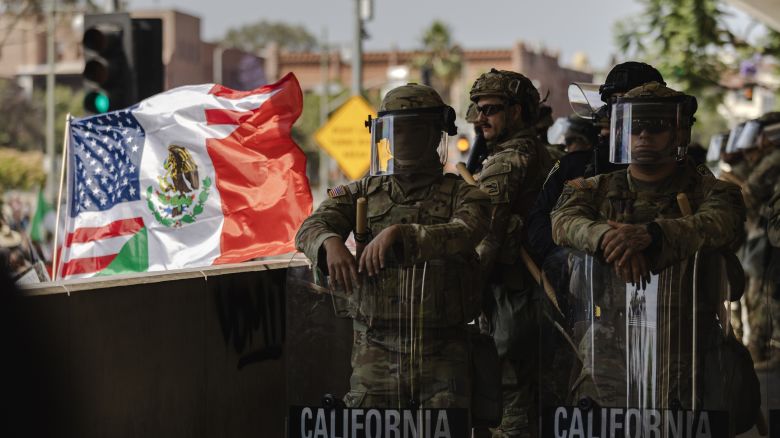 LOS ANGELES, CALIFORNIA - JUNE 09: A United States of America and Mexico hybrid flag is flown next to National Guard standing guard outside of the Edward Roybal Federal Building as protesters gather on June 9, 2025 in Downtown Los Angeles, California. Tensions in the city remain high after the Trump istration called in the National Guard against the wishes of city leaders. (Photo by Jim Vondruska/Getty Images)