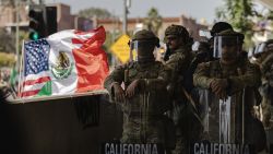 LOS ANGELES, CALIFORNIA - JUNE 09: A United States of America and Mexico hybrid flag is flown next to National Guard standing guard outside of the Edward Roybal Federal Building as protesters gather on June 9, 2025 in Downtown Los Angeles, California. Tensions in the city remain high after the Trump istration called in the National Guard against the wishes of city leaders. (Photo by Jim Vondruska/Getty Images)