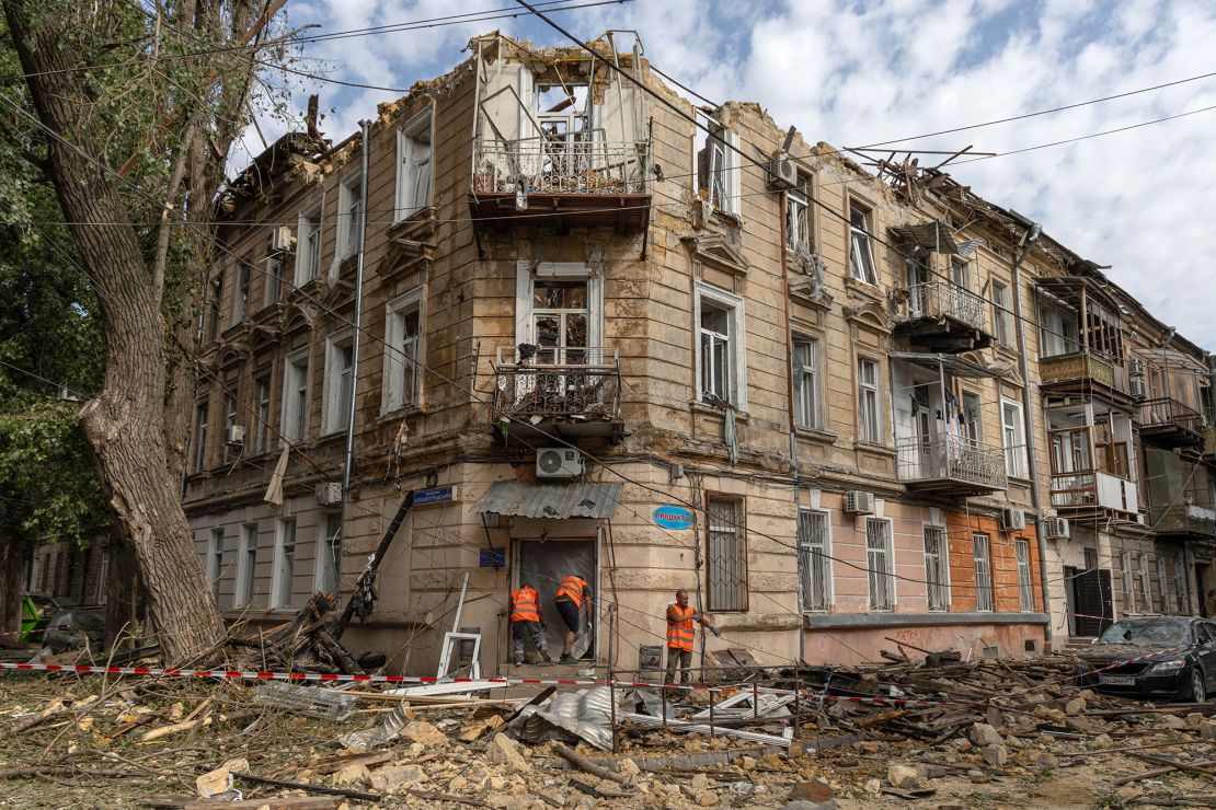 Workers will clean up debris next to the damaged residential building after being attacked by a Russian drone in Odesa on June 10, 2025.
