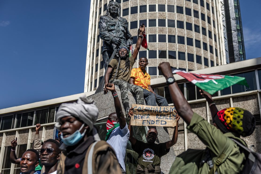 Protesters chant slogans surrounding the statue of Kenyan leader against the British colonial rule, Dedan Kimathi, as they march demanding the resignation of senior officers.