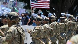 of the California National Guard form a line near the entrance to a federal building's loading dock and parking garage, where a small group of protesters gathers amid ongoing demonstrations in response to federal immigration operations, on June 10, 2025, in downtown Los Angeles. US President Donald Trump on June 10 claimed Los Angeles was being invaded by a "foreign enemy" and vowed to "liberate" the city after days of protests sparked by immigration raids. Trump has deployed thousands of troops including 700 active duty US Marines to Los Angeles, despite California authorities saying the move is unnecessary and will inflame the situation. (Photo by Robyn Beck / AFP) (Photo by ROBYN BECK/AFP via Getty Images)