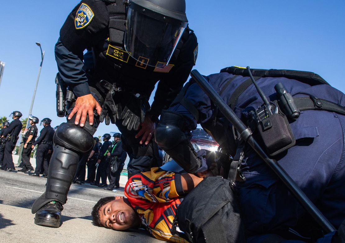 California Highway Patrol officers arrest a demonstrator in the overpass of the 101 Freeway as protests continue in response to federal immigration operations in Los Angeles on June 10, 2025.